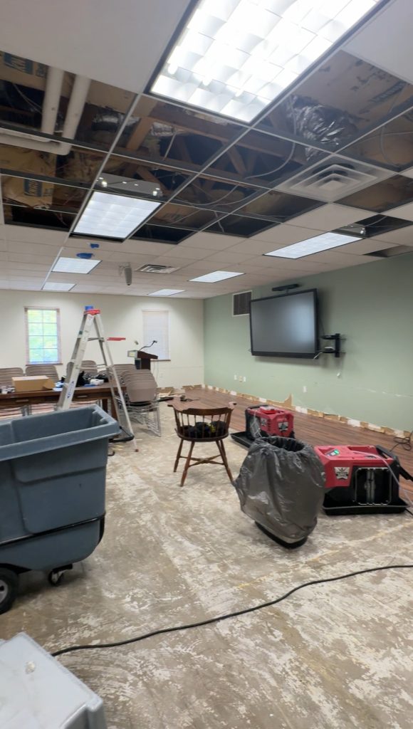 Community Room with fans, missing ceiling tiles and flooring removal