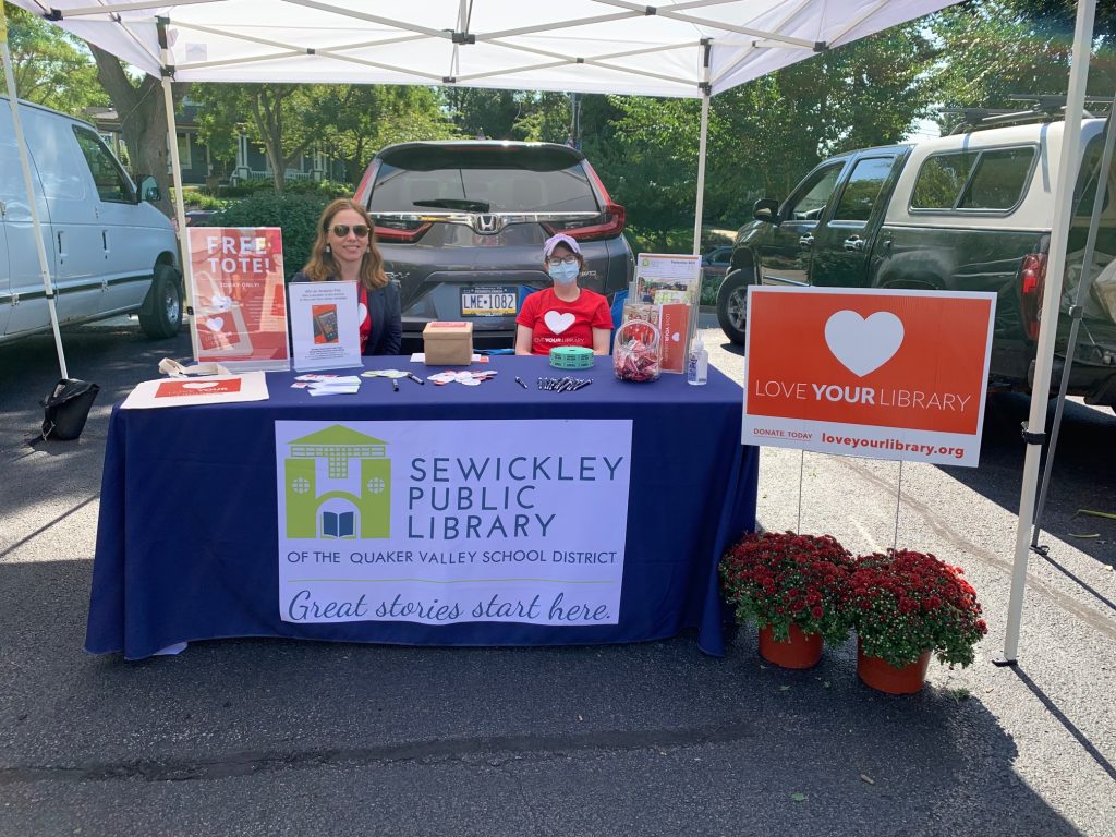 Outreach at the Farmer's Market - Image of two library staff members at a table with SPL tablecloth