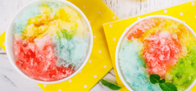 Snow Cone Kick-Off Party Three bowls of colorful shaved ice with mint leaves on yellow polka-dot napkins.