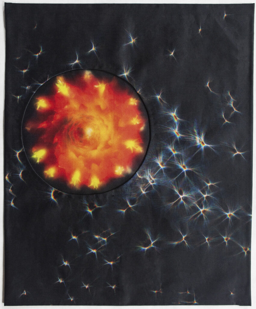 Photographic collage on fabric with a circular orange flower element on a dark background with white starlike shapes.